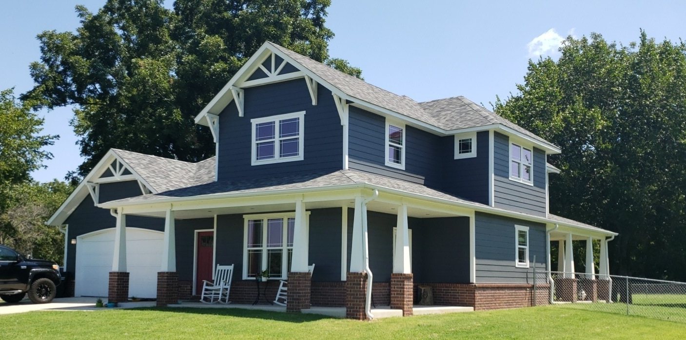 Two-story craftsman custom home with blue siding and covered porch near Claremore