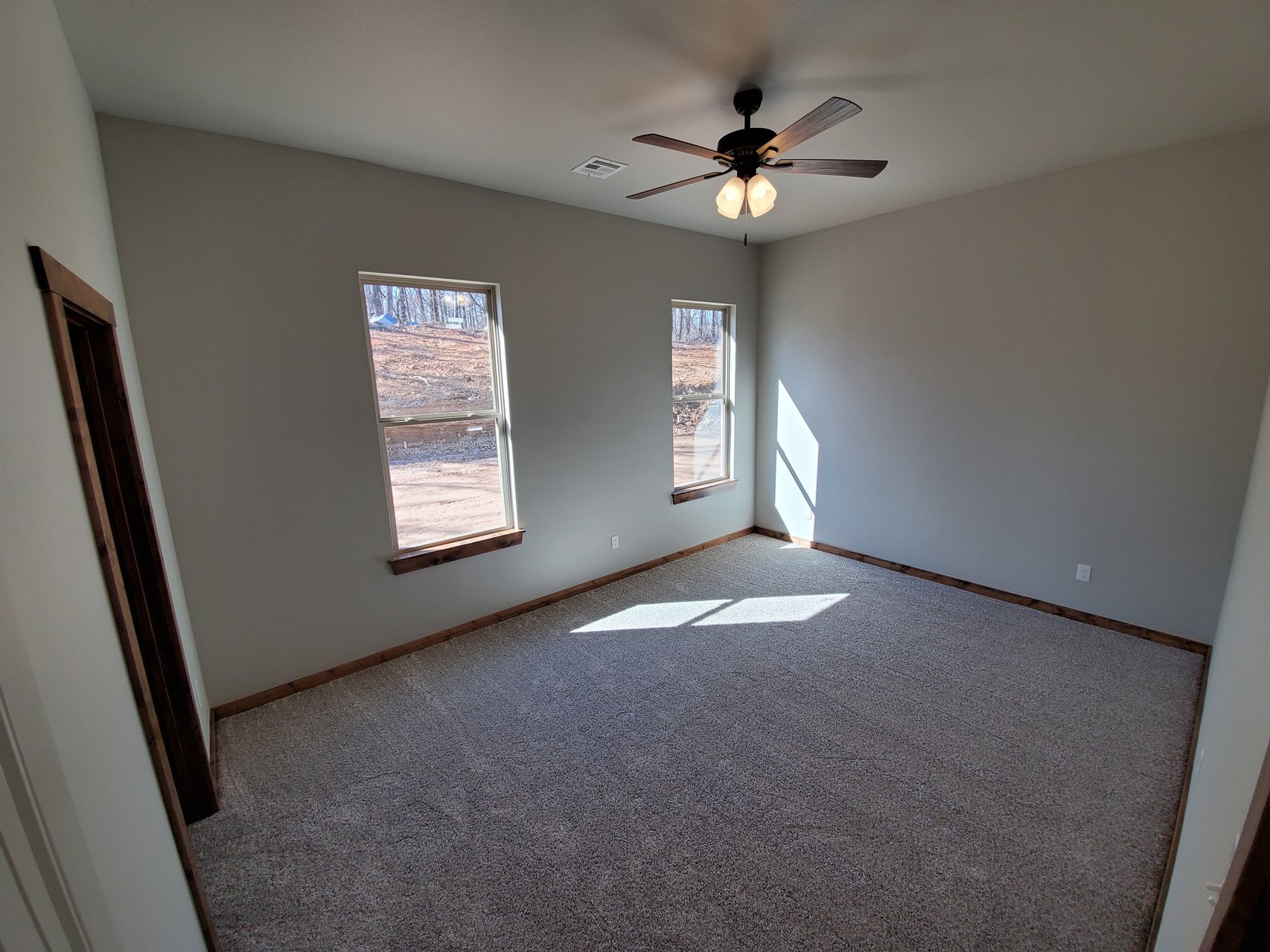 Finished bedroom with carpet, ceiling fan, and wood window trim