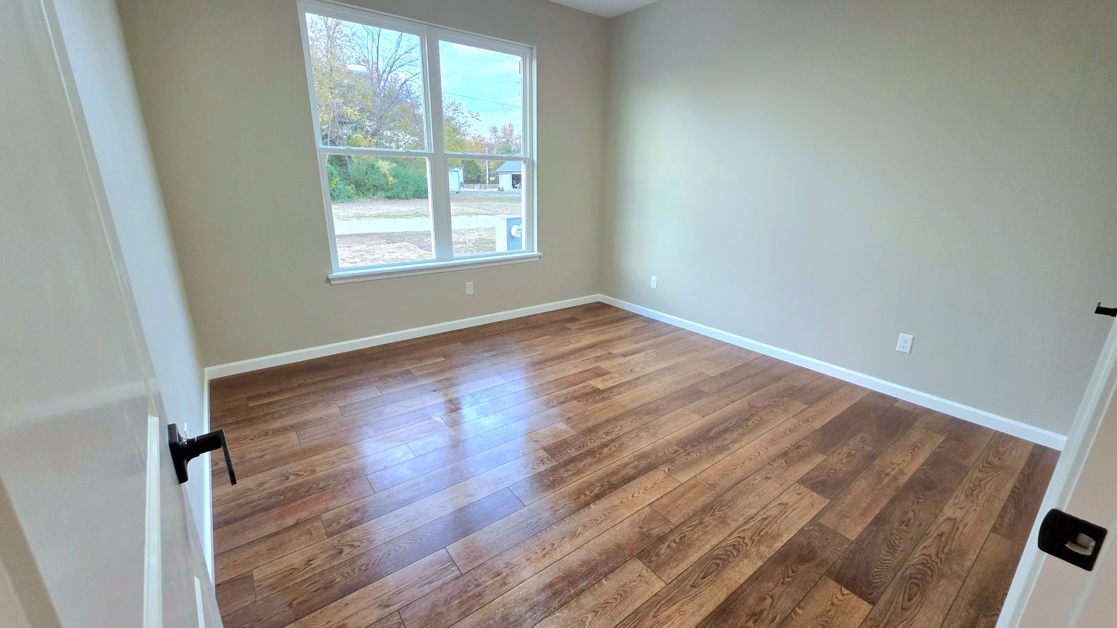 Open living room with hardwood floors in custom home