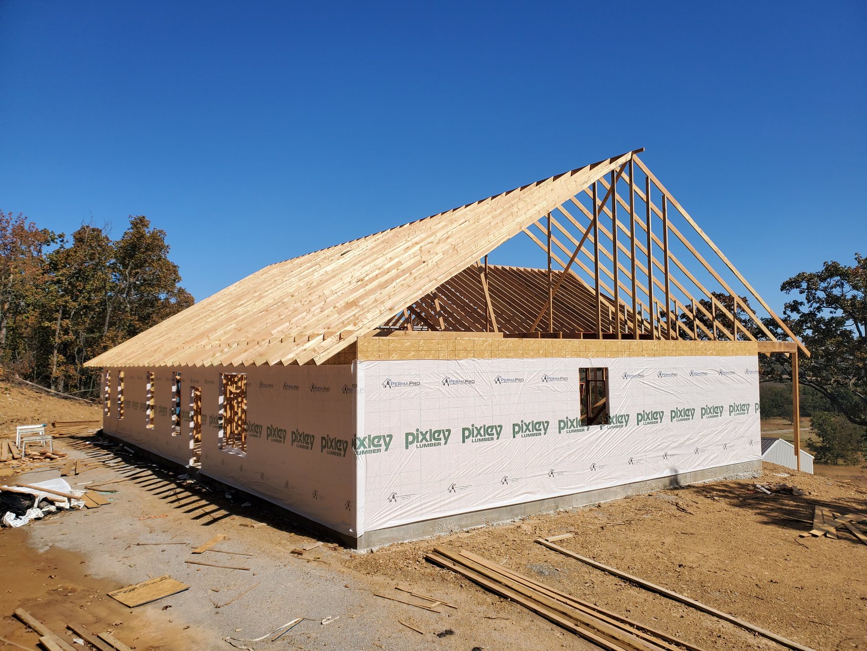 Roof truss framing and housewrap on a custom home build in northeast Oklahoma