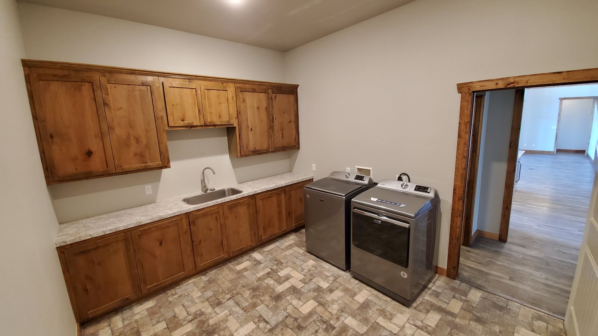 Laundry room with wood cabinets and counter sink