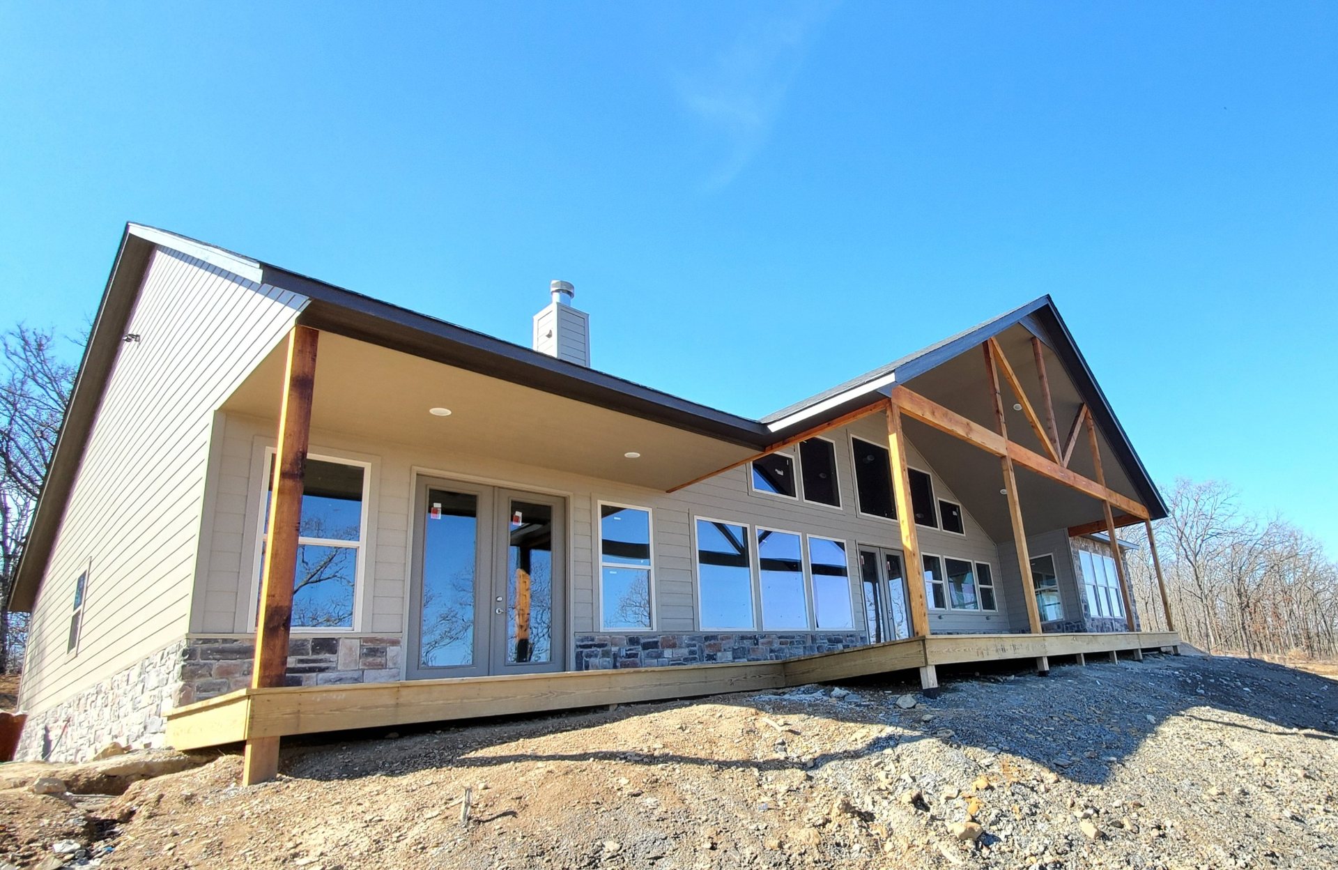 Finished lake-area custom home with timber covered porch and stone foundation