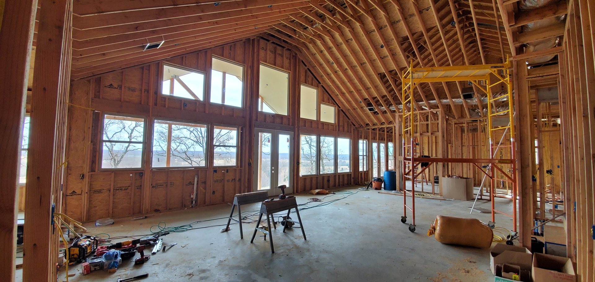 Vaulted great room framing with large windows overlooking the landscape