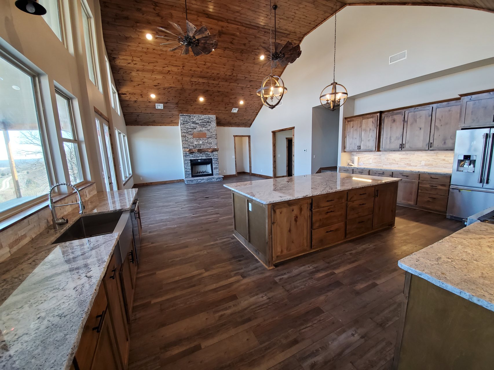 Custom kitchen with wood cabinets, granite island, and vaulted wood ceiling