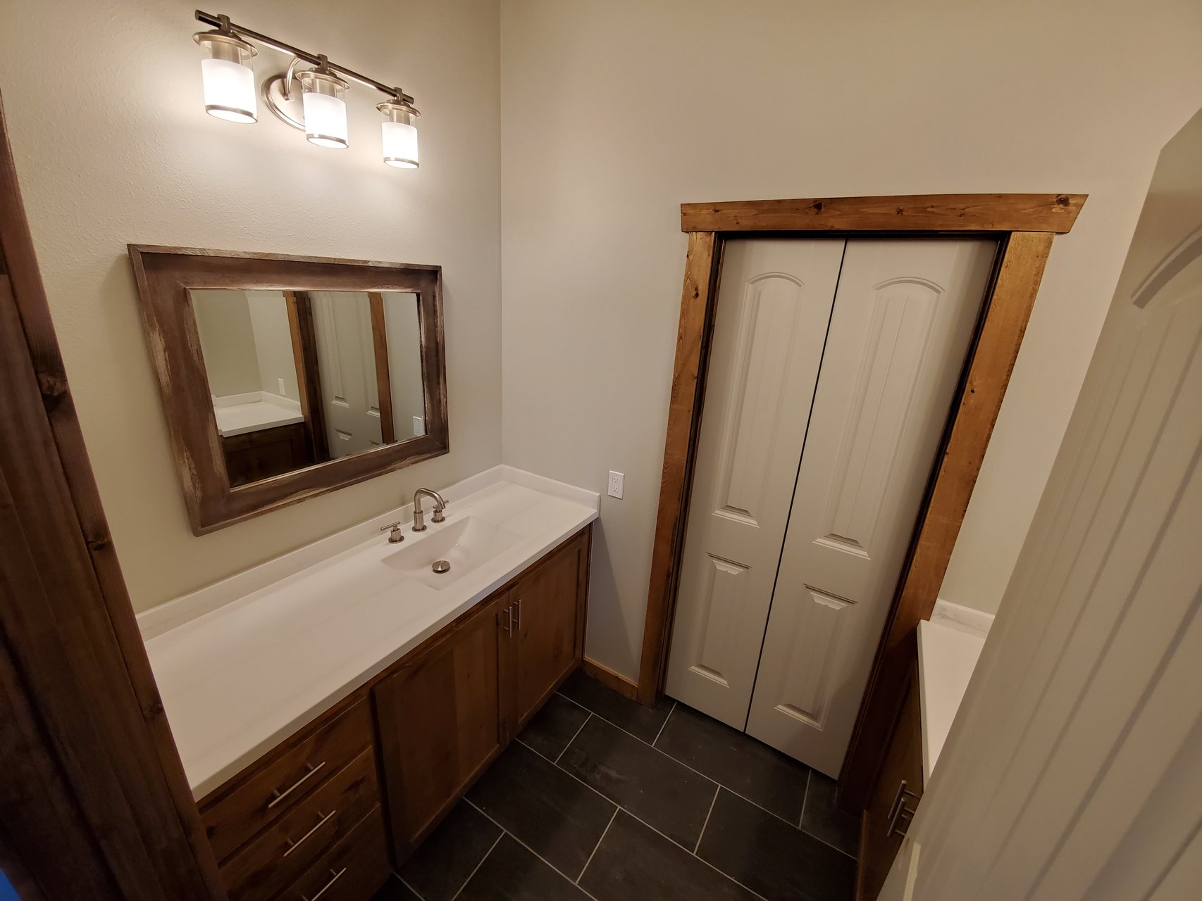 Powder room with wood vanity and slate floor tile