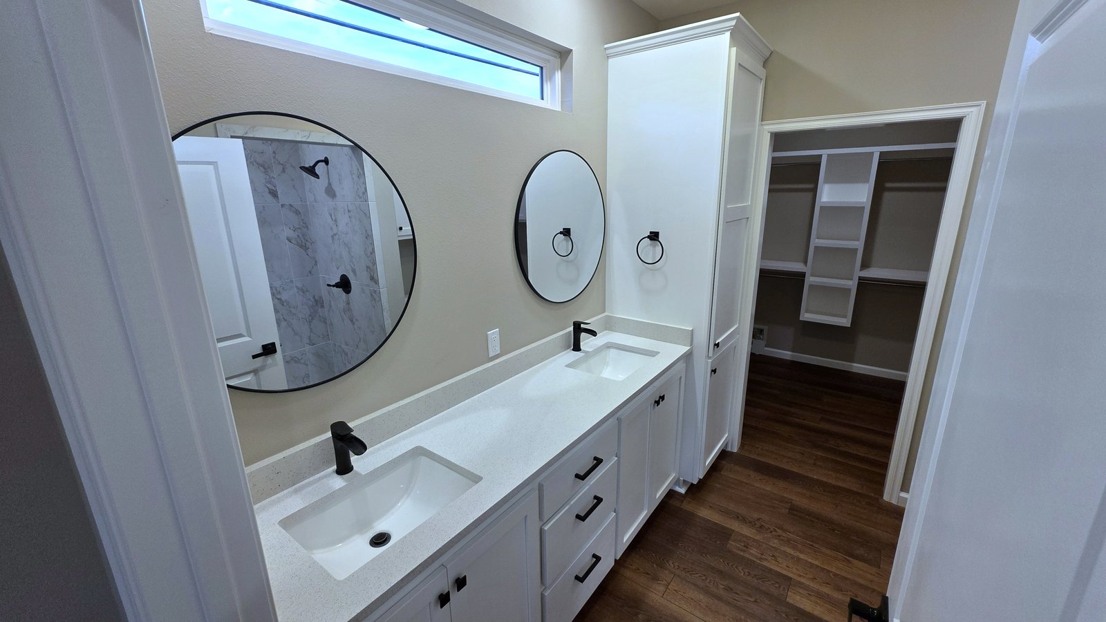 Primary suite bathroom vanity with round mirrors