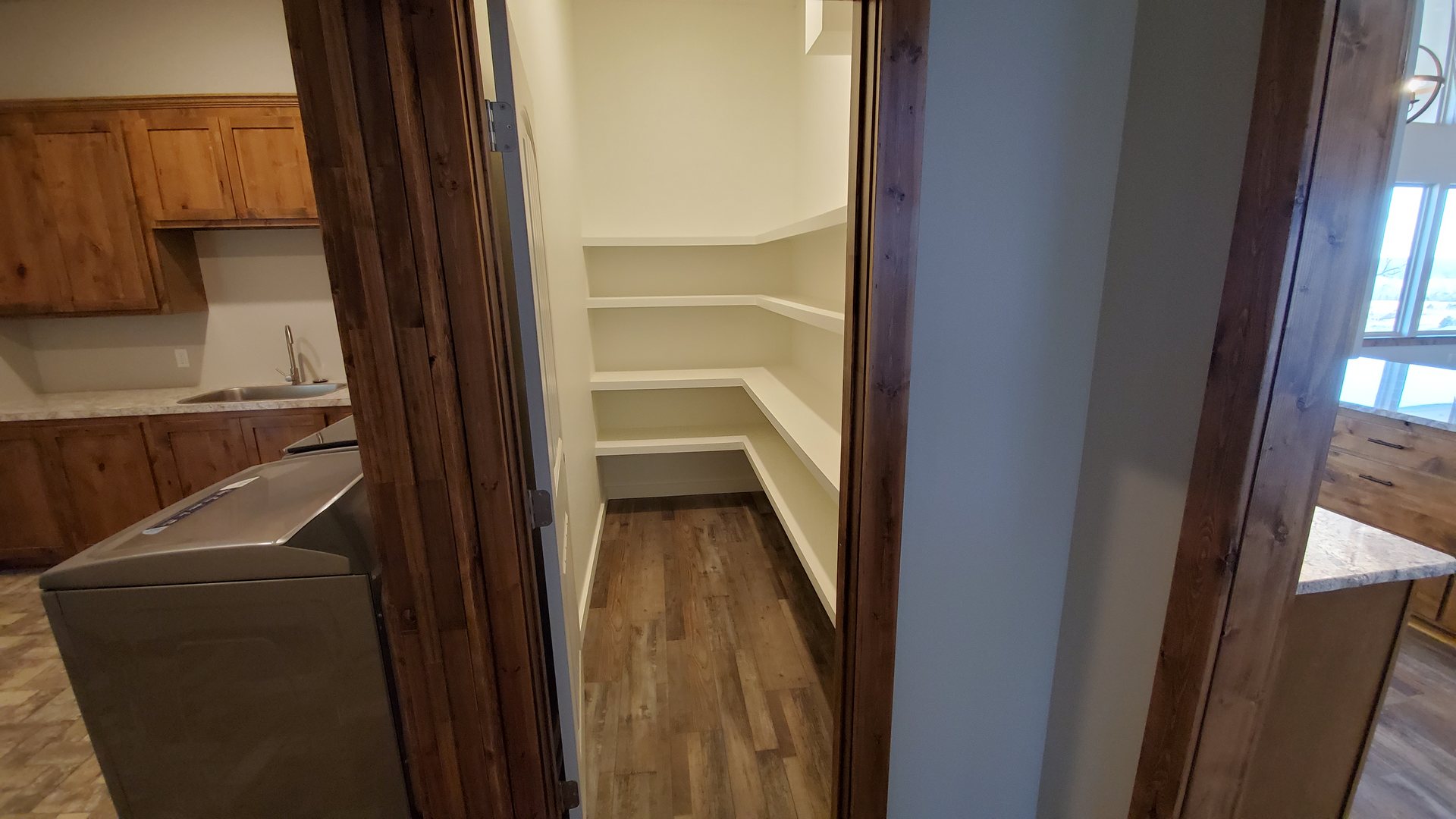 Walk-in pantry with custom shelving off the laundry and kitchen